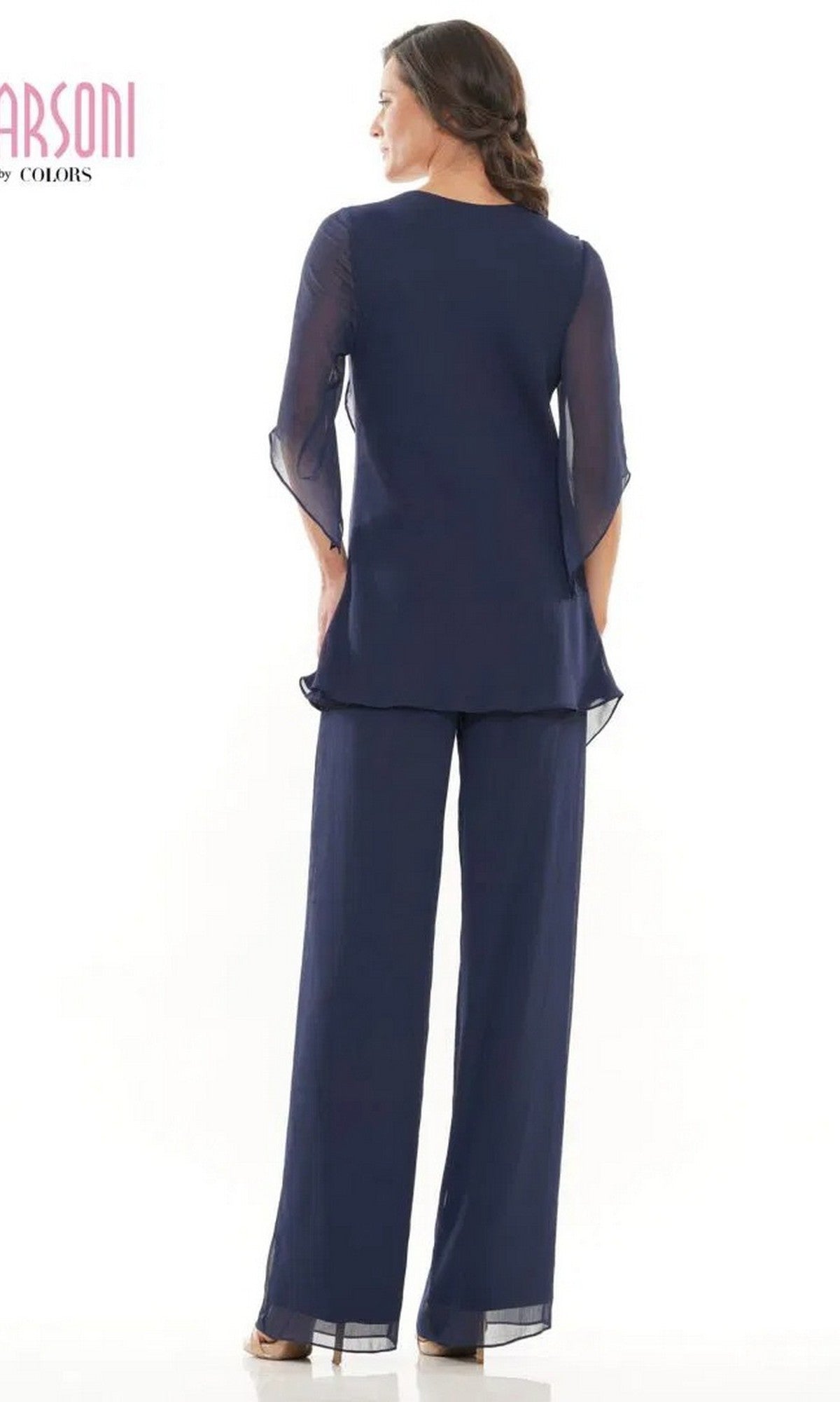 A woman stands with her back to the camera, wearing a navy blue Long Formal Pantsuit: Marsoni M308 with sheer sleeves and wide-leg chiffon pants.